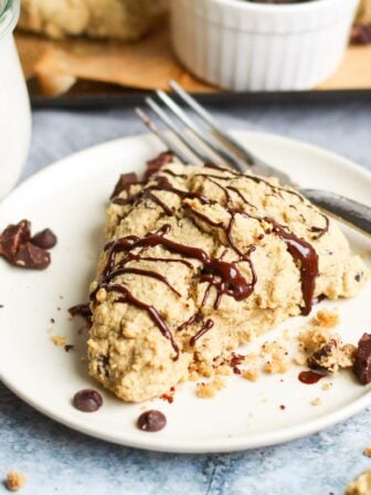chocolate chip scone on a plate with chocolate drizzle
