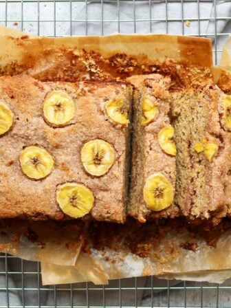 paleo cinnamon swirl almond bread with a slice smeared in almond butter on a drying rack