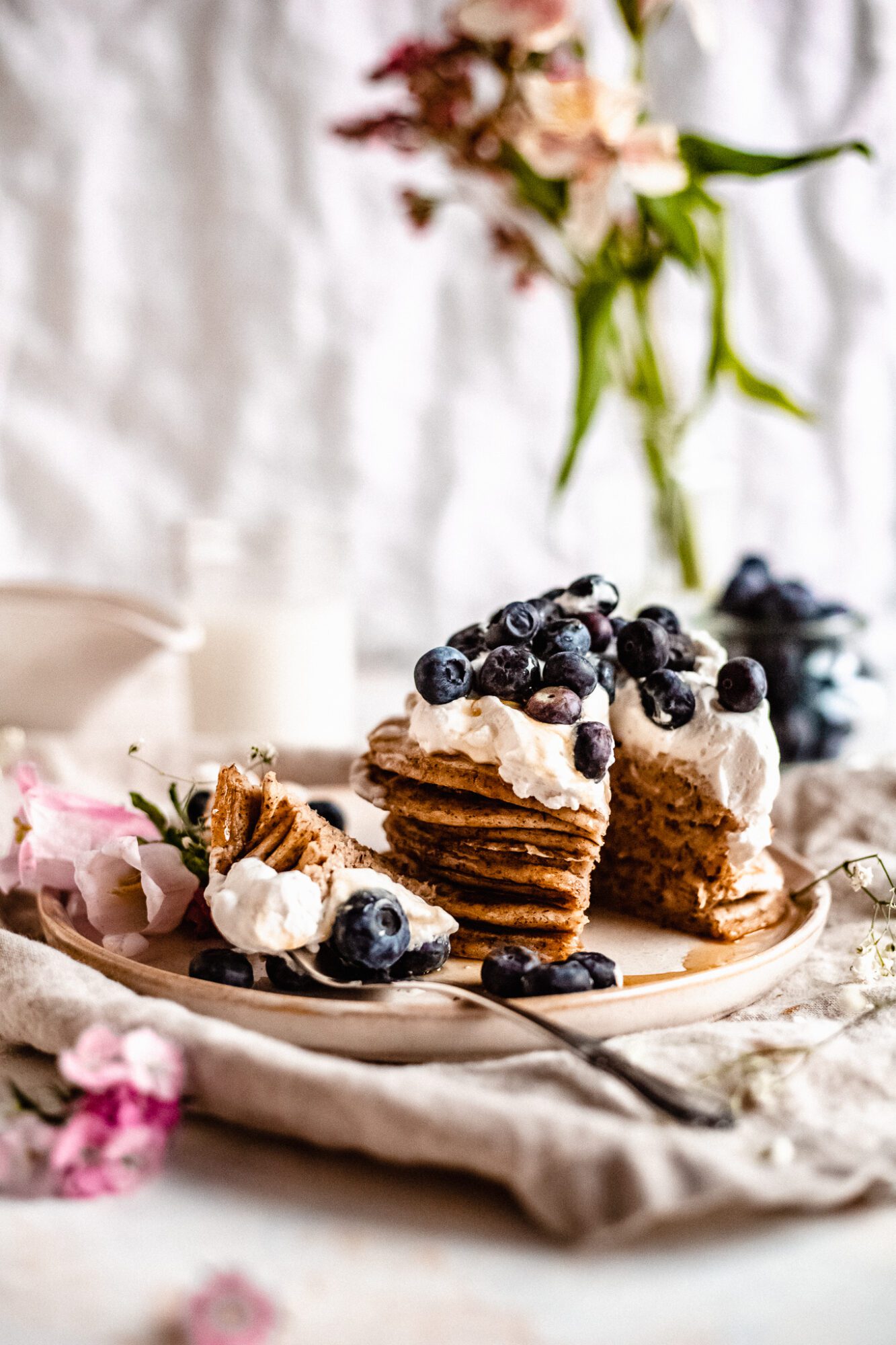 sliced gluten free pancakes with whipped cream and blueberries