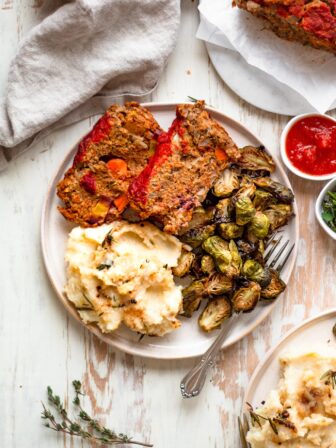 overhead of plate with lentil meatloaf, mashed potatoes, and brussels sprouts