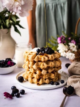 vegan gluten free waffles being drizzled with maple syrup