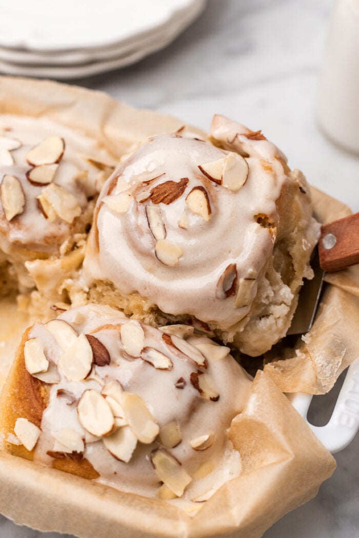 soft almond sweet roll being pulled from baking dish