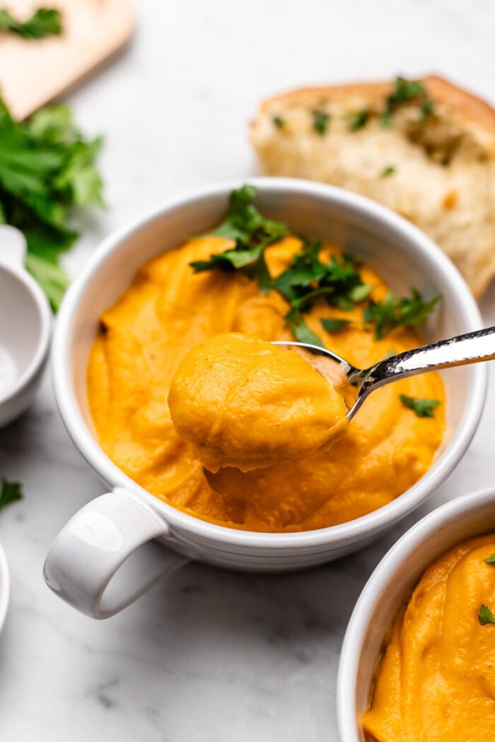bowl of butternut squash sweet potato soup with spoon in it