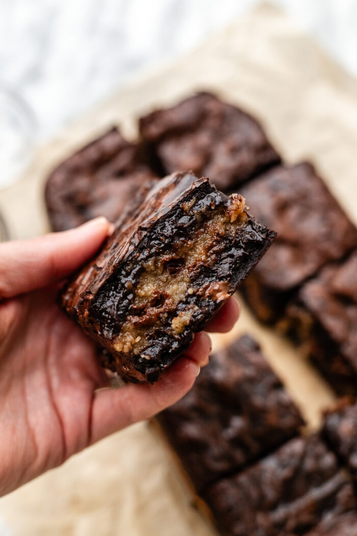 hand holding cookie dough stuffed brownie