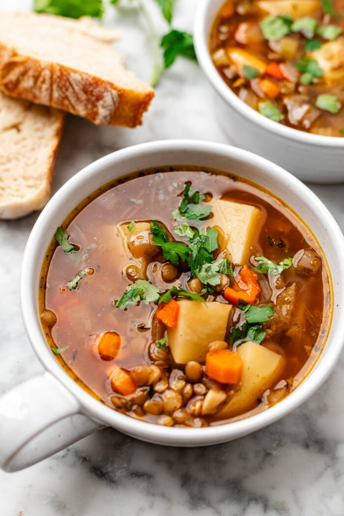 bowls of potato soup with bread next to it