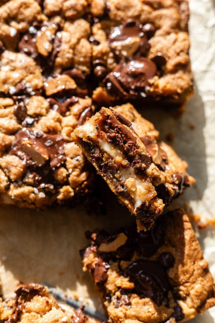 sliced peanut butter cheesecake cookie bars on parchment paper