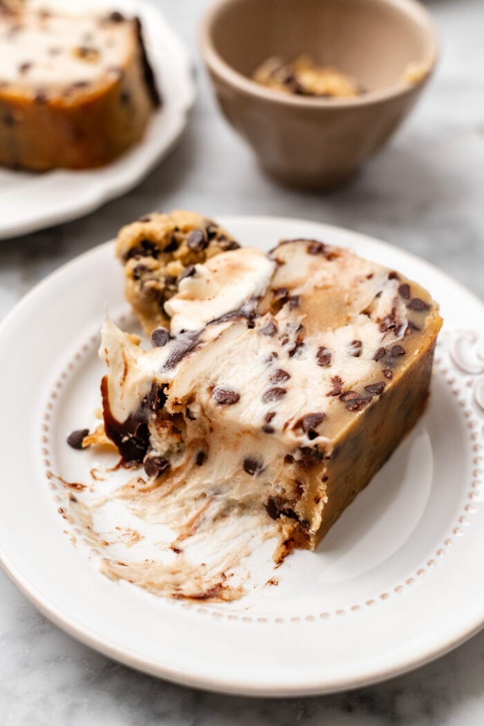 bitten slice of small batch vegan cookie dough cheesecake on a white plate