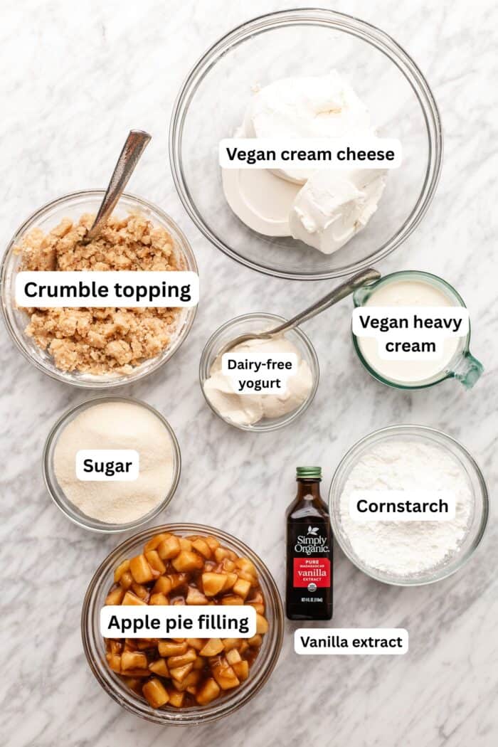 apple crumble cheesecake ingredients on a marble slab.