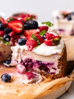 sliced vegan berry chantilly cheesecake on wooden board