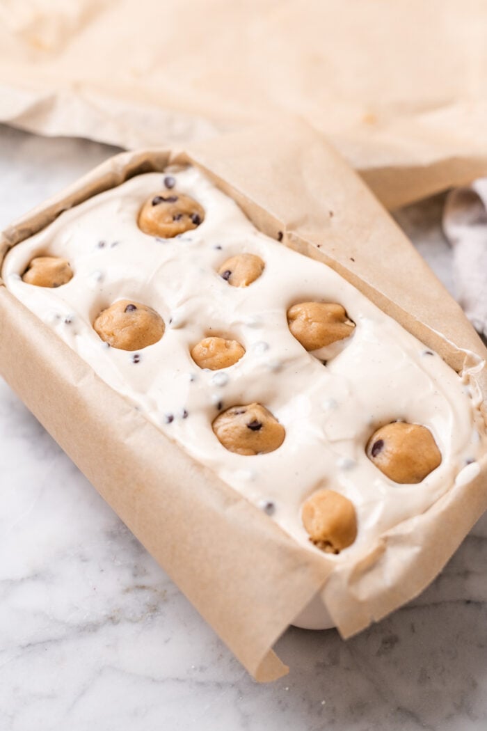 pressing cookie dough into cheesecake batter