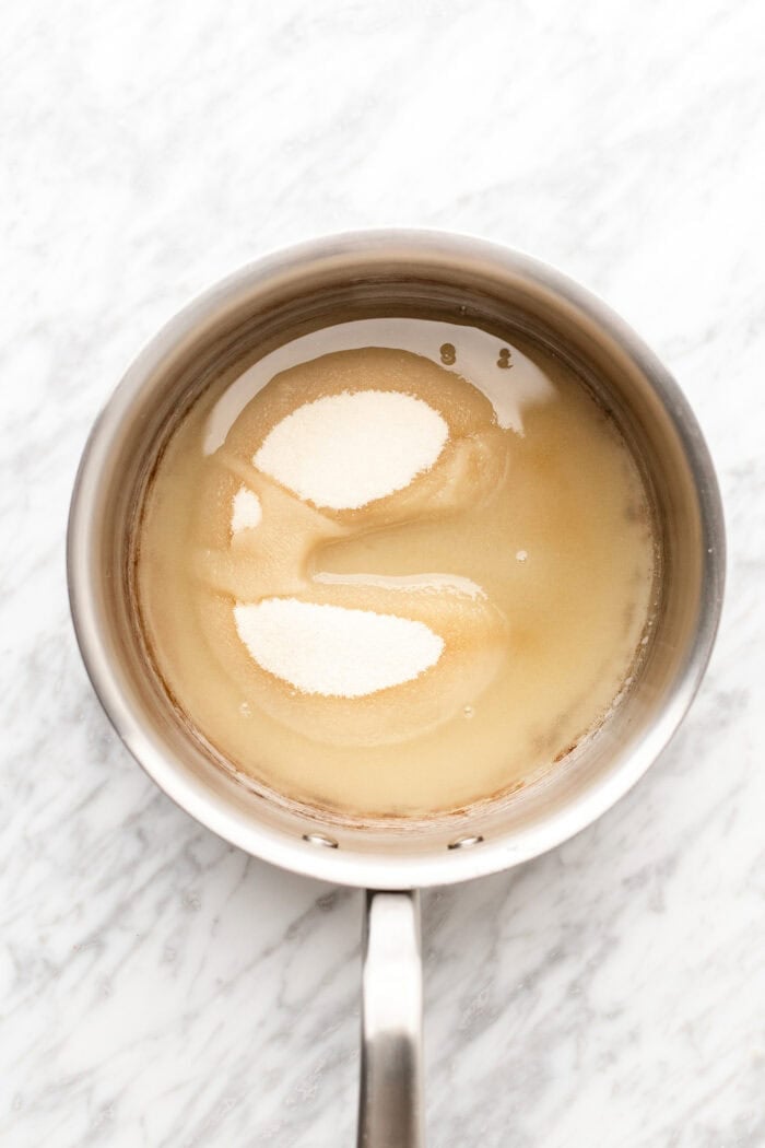 sugar and water in a saucepan on a marble able.