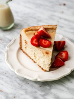 slice of vegan cheesecake with strawberries on a plate