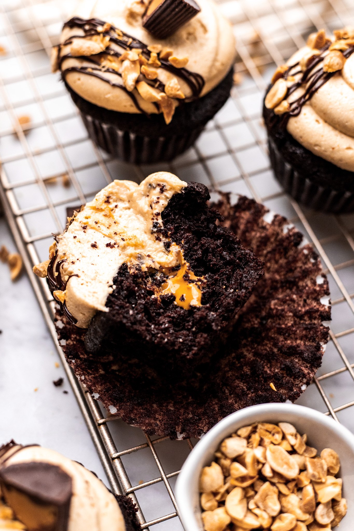bitten chocolate peanut butter cupcake on cooling rack