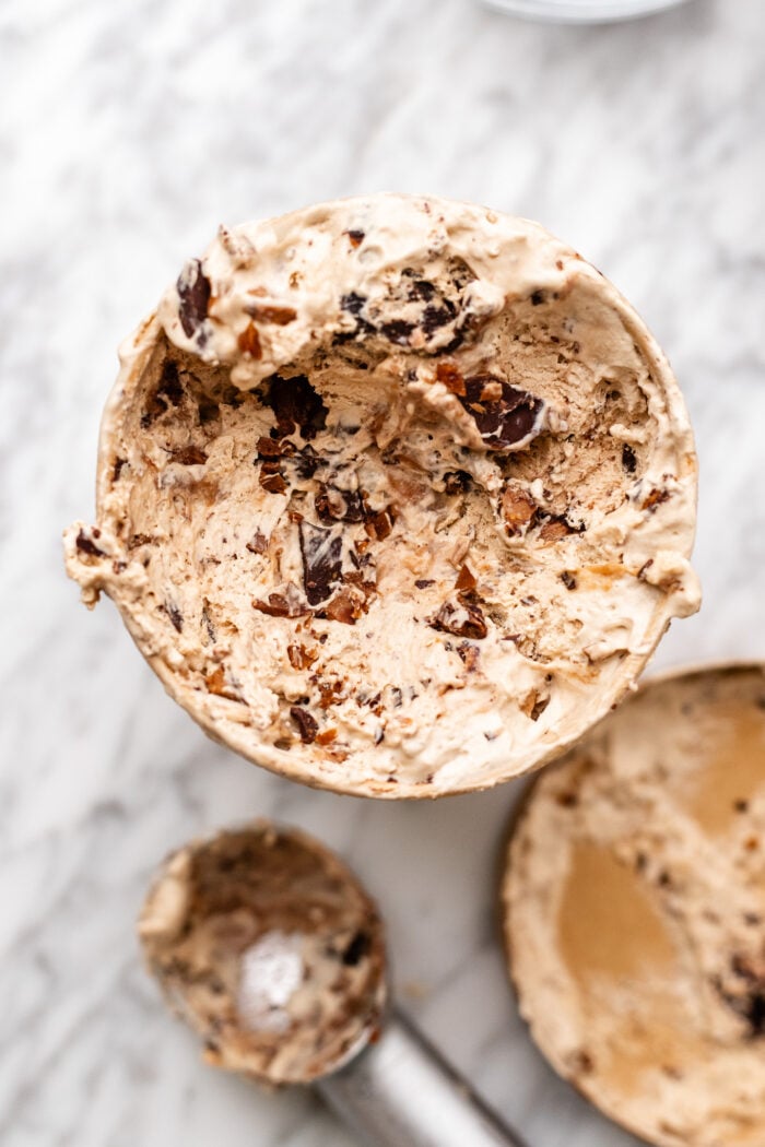 pint of toffee bar crunch ice cream being scooped