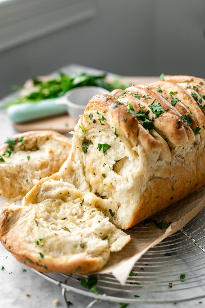 pull apart bread with herbs in the background
