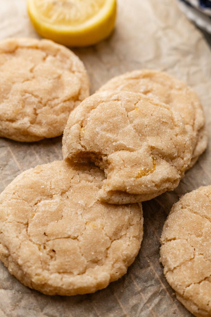 bitten lemon sugar cookie on a parchment paper baking sheet