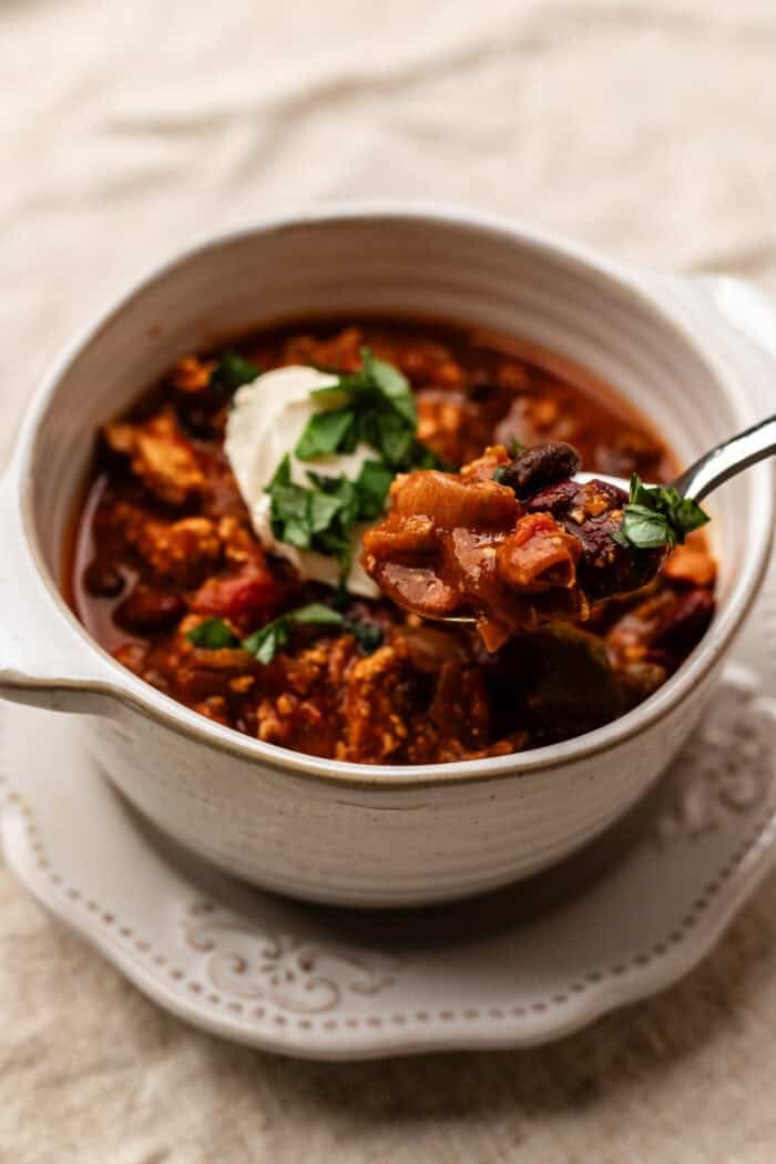 bowl of pumpkin chili with a spoon in it.