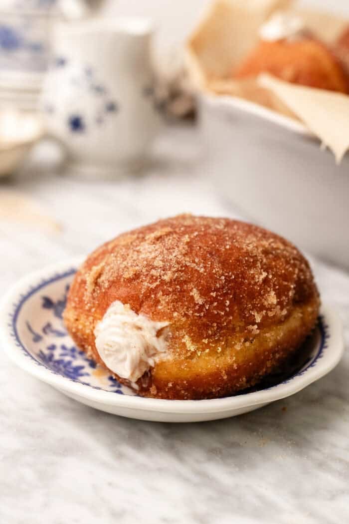 pumpkin spice doughnut on a blue plate on a marble table.